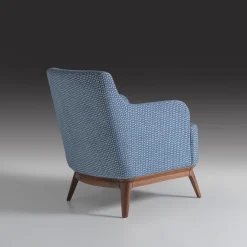 Poltrona imbottita di colore azzurro con piedi in noce canaletto