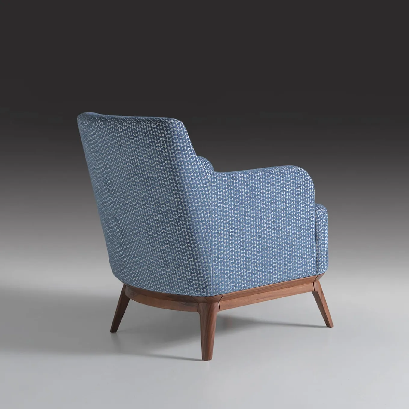 Poltrona imbottita di colore azzurro con piedi in noce canaletto