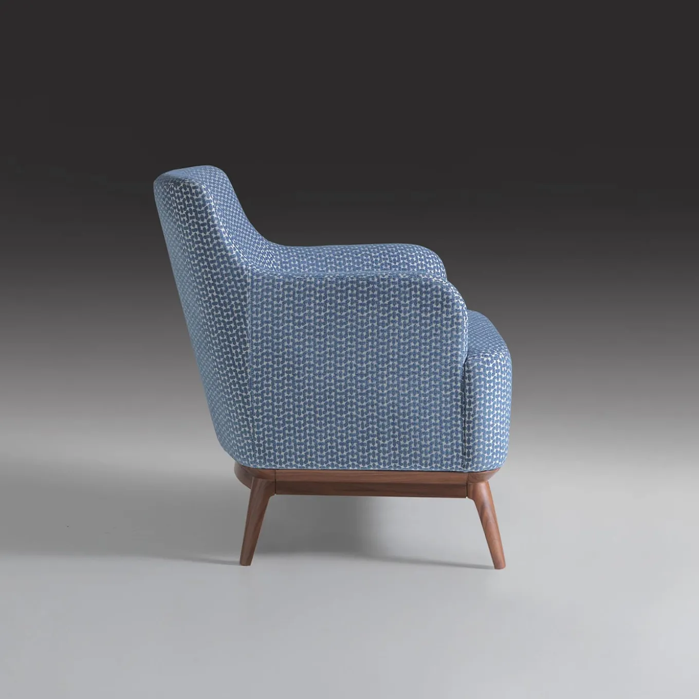 Poltrona imbottita di colore azzurro con piedi in noce canaletto