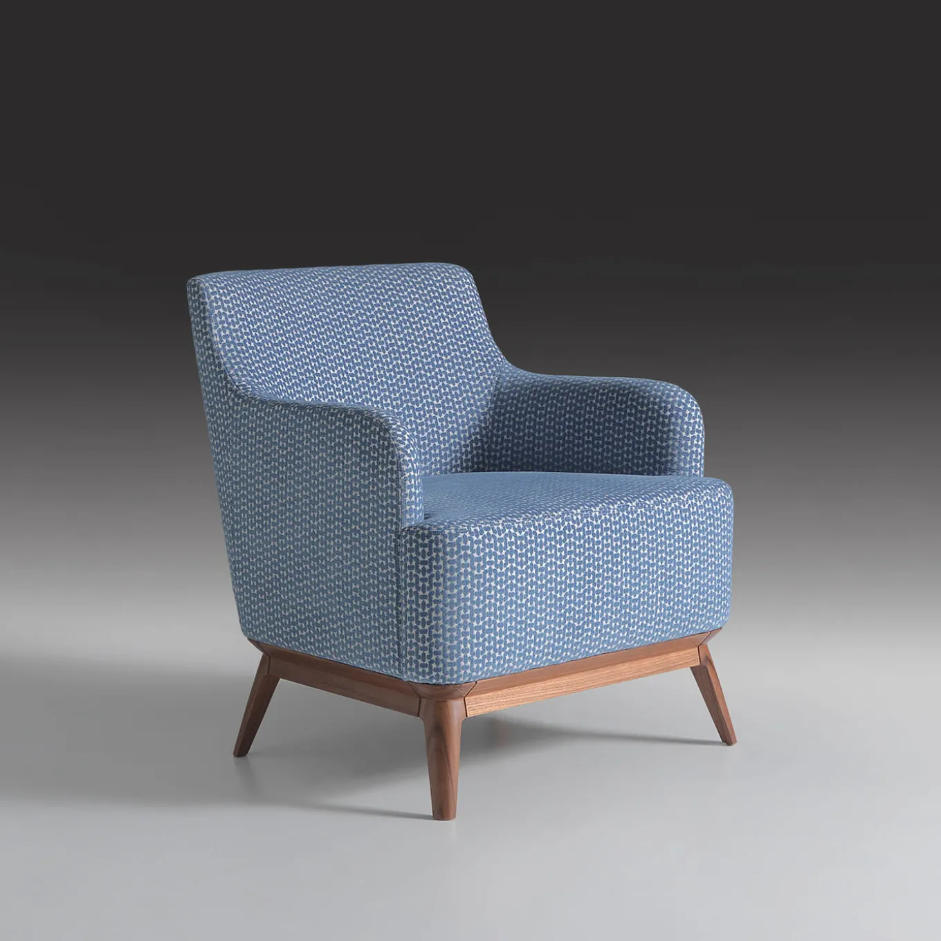 Poltrona imbottita di colore azzurro con piedi in noce canaletto