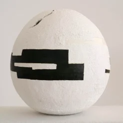 Sfera di cemento bianco con inserti geometrici neri
