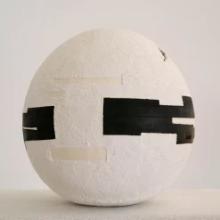 Sfera di cemento bianco con inserti geometrici neri
